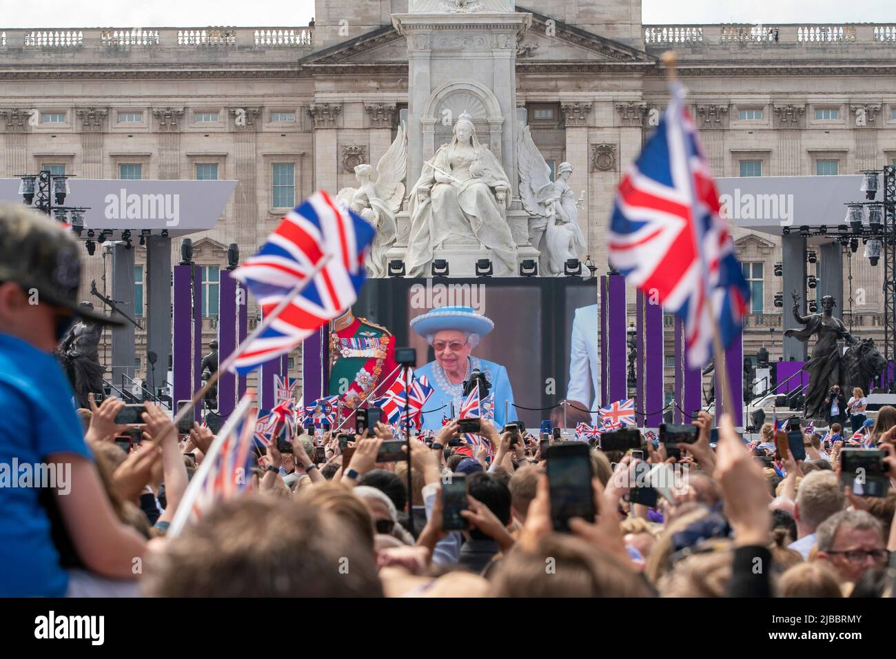 La folla sul Mall guarda la famiglia reale, inclusa la Regina su uno schermo gigante fuori da Buckingham Palace per le celebrazioni del Platinum Jubilee Foto Stock