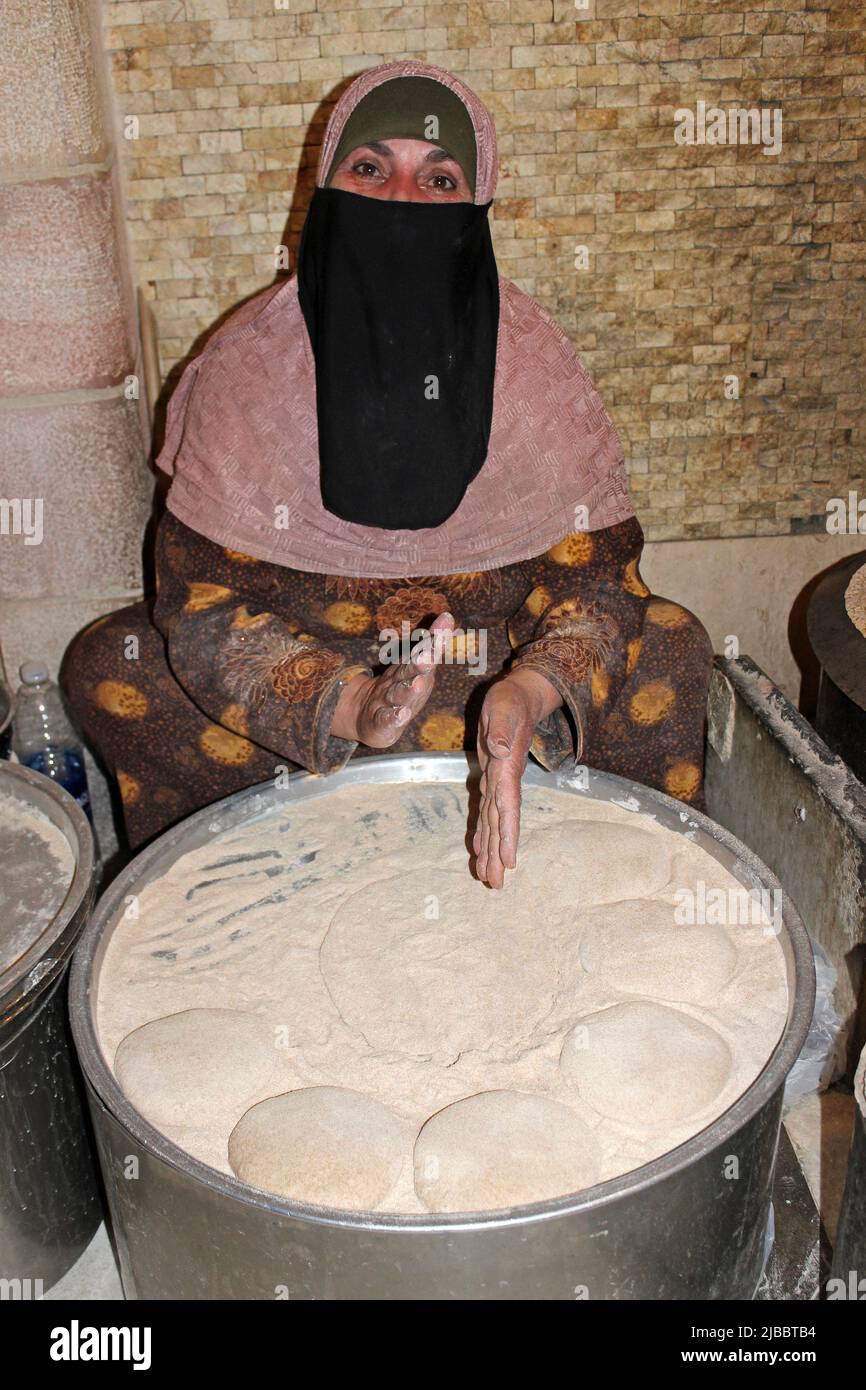 Donna giordana che prepara il pane beduino - un pane piatto chiamato Shrak Foto Stock