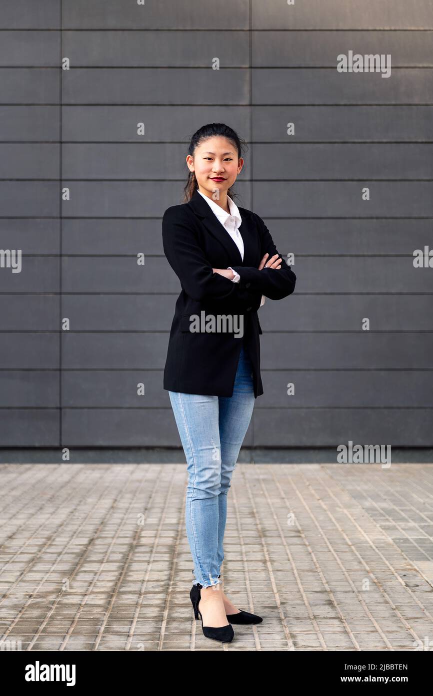 donna imprenditore sorridente con le braccia ripiegate Foto Stock