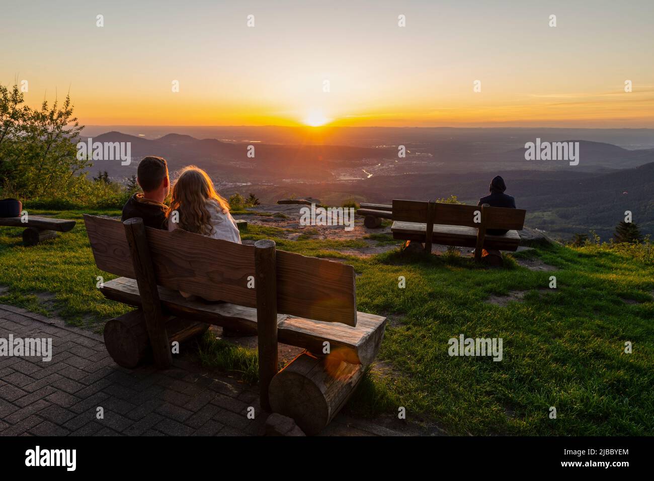 I visitatori e gli amanti del Mulino del Diavolo nella Foresta Nera si siedono sulle panchine e guardano il tramonto sulla Murg e sulla valle del Reno, in Germania Foto Stock