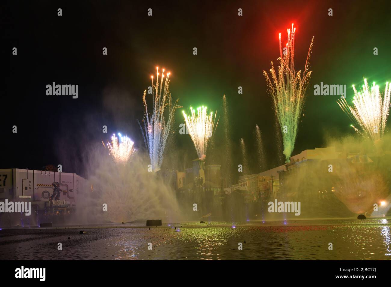 Combinazione di fuochi d'artificio e acqua della fontana illuminata durante lo spettacolo di fine giornata. Vista frontale della merce in un negozio di articoli da regalo. Universal Studios Fl Foto Stock