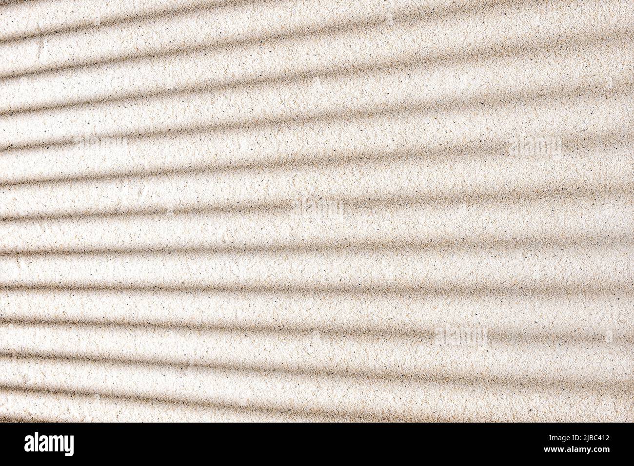 Strisce geometriche di ombre su uno sfondo di sabbia pulito Foto Stock
