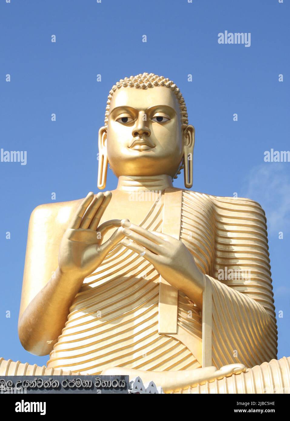 Il Buddha d'oro del 5th secolo sorge sopra il Tempio d'Oro a Sigiriya, a Dambulla, vicino al complesso del Tempio di Dambulla nello Sri Lanka. La postura è Dharma Cha Foto Stock