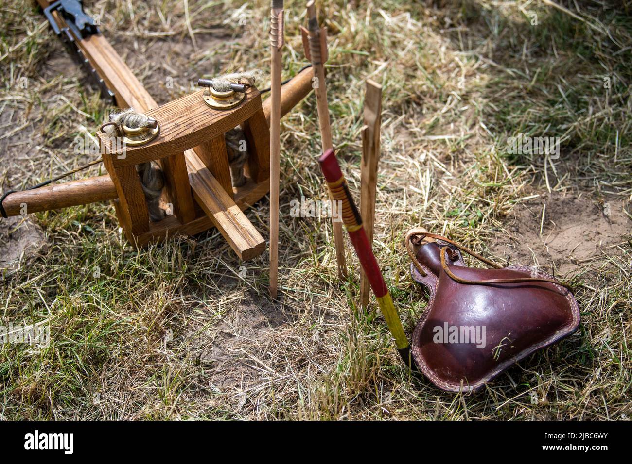 Bramsche, Germania. 05th giugno 2022. Una bottiglia d'acqua si trova accanto ad una balestra e frecce. Le Giornate Romane e Germaniche del Museo e Parco Kalkriese attirano centinaia di visitatori in un altro periodo. Centinaia di artisti provenienti da tutta Europa ricreano l'epoca romana in scontri e artigianato. Credit: Lino Mirgeler/dpa/Alamy Live News Foto Stock