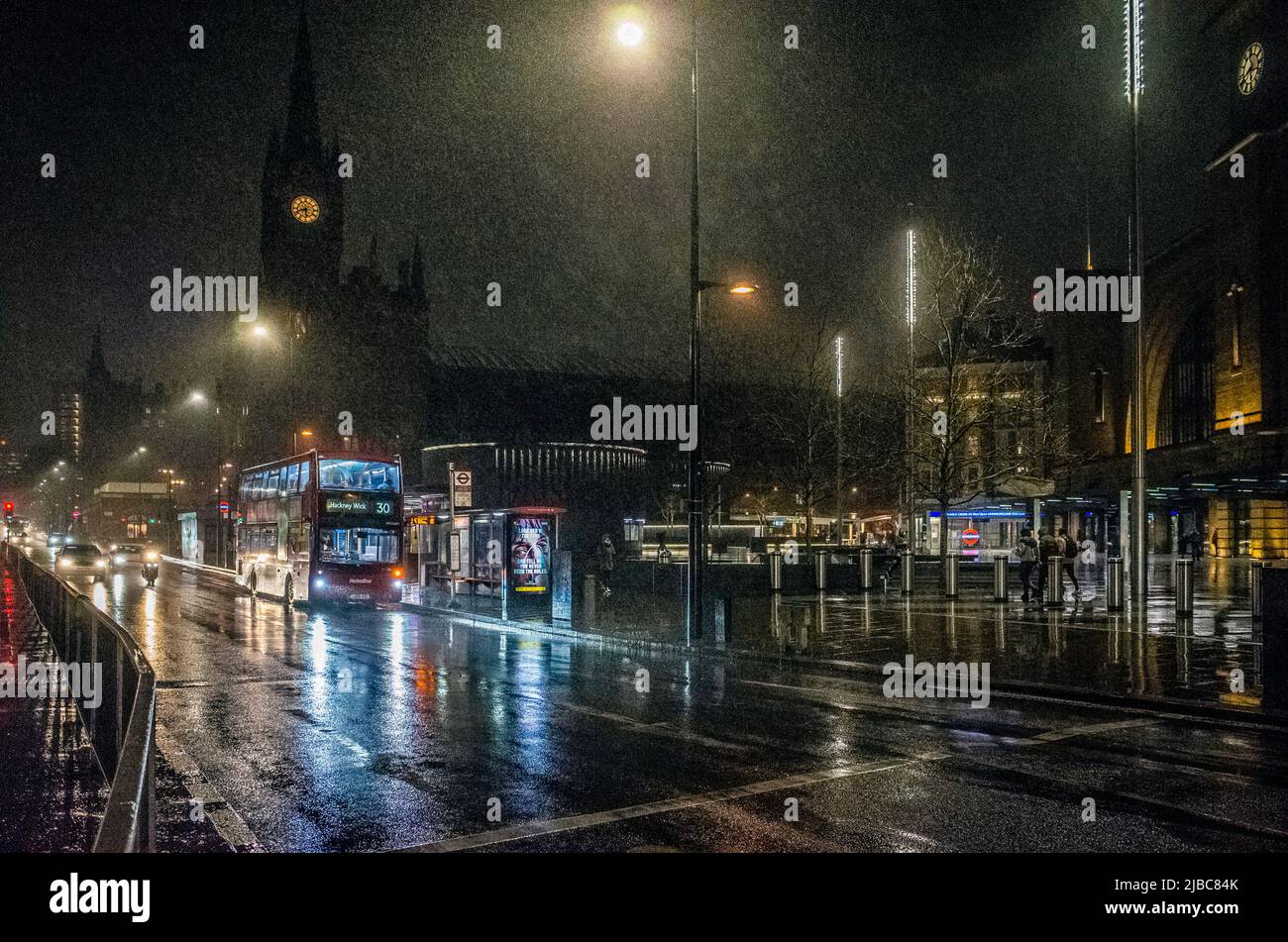 Stazione ferroviaria di Kings Cross e autobus su Euston Road, Londra, foto notturne sotto la pioggia battente. Foto Stock