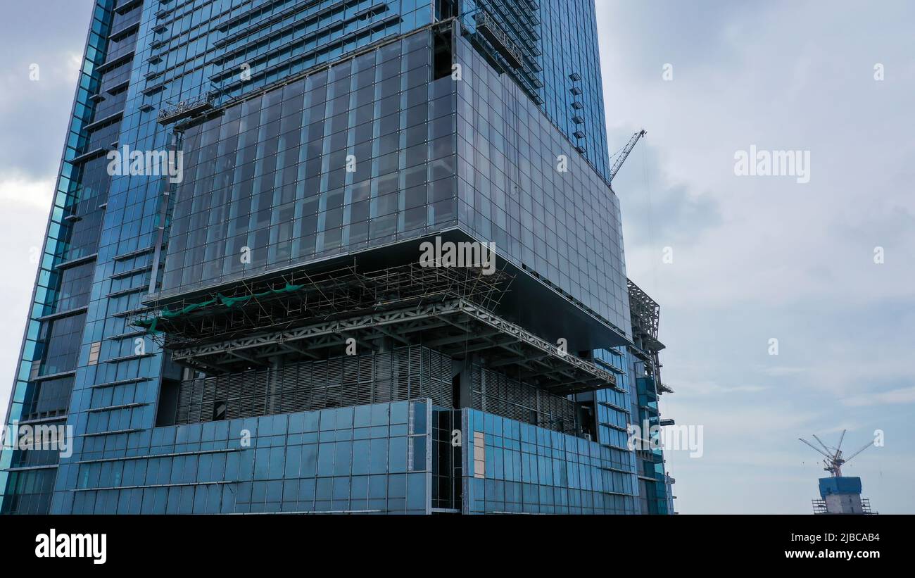 Primo piano di alti edifici in costruzione, esterni. Edificio futuristico e dal design moderno con grattacielo blu. Costruzione Foto Stock