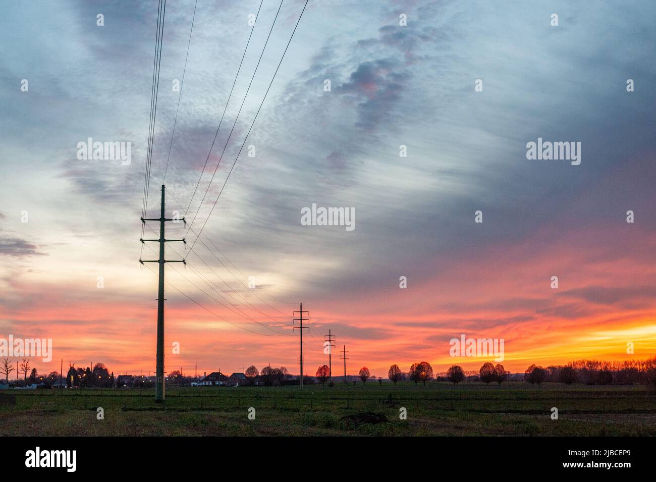 Il sole che tramonta sul lato fiammingo colora il cielo intensamente giallo e arancione. Foto Stock