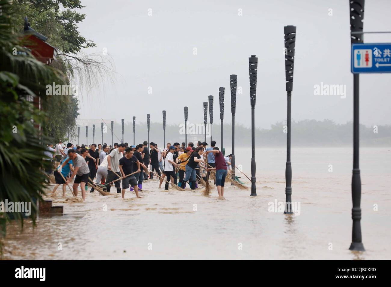 LIUZHOU, CINA - 5 GIUGNO 2022 - la gente pulisce il limo da una banca di fiume in Liuzhou, Cina del sud la regione autonoma di Guangxi Zhuang, 5 giugno 2022. Foto Stock