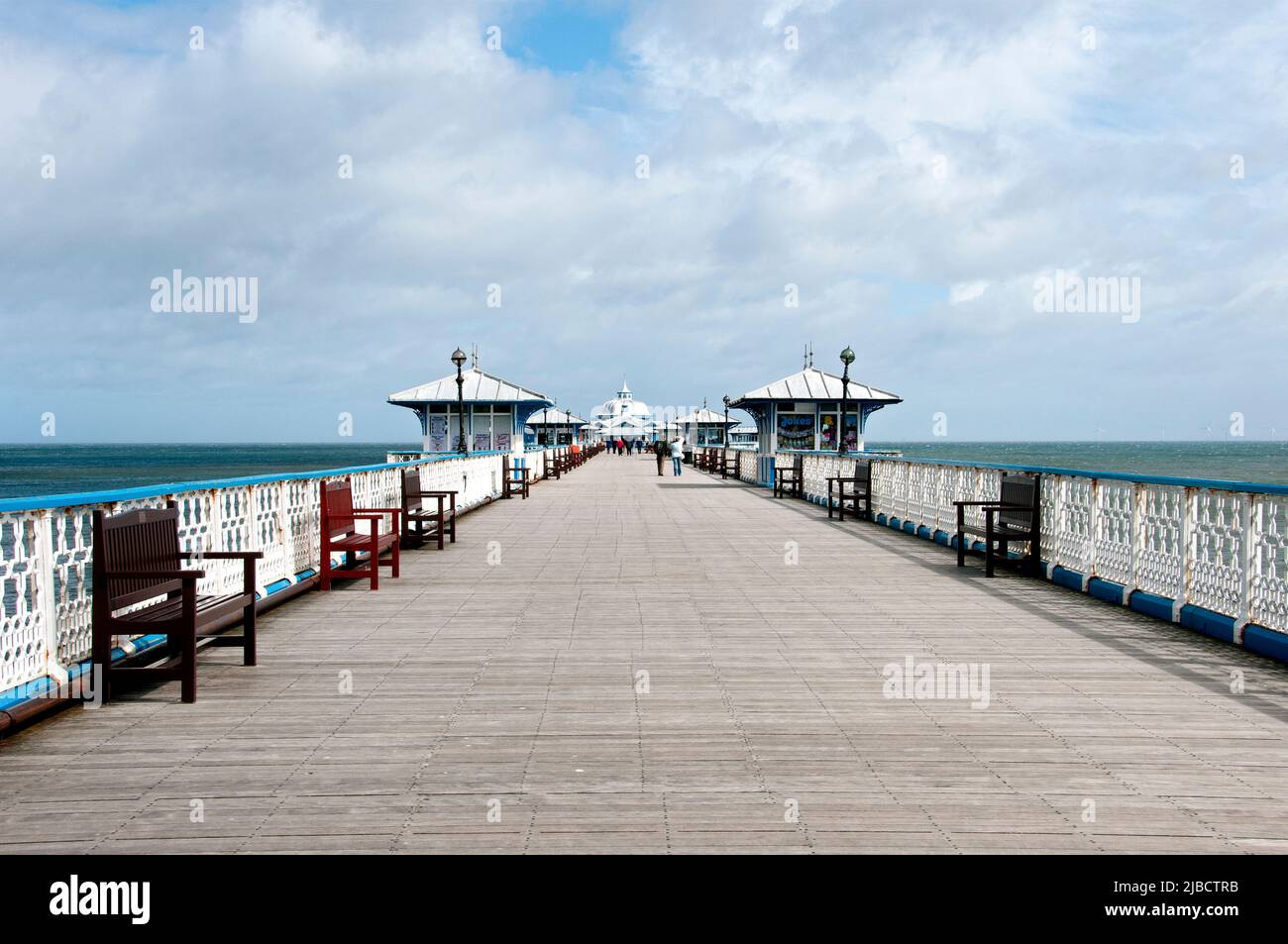 La gente si gode una passeggiata lungo il molo vittoriano di Llandudno, classificato da 2295 piedi di grado II, che si estende nel Mare d'Irlanda, completato nel 1878 Foto Stock