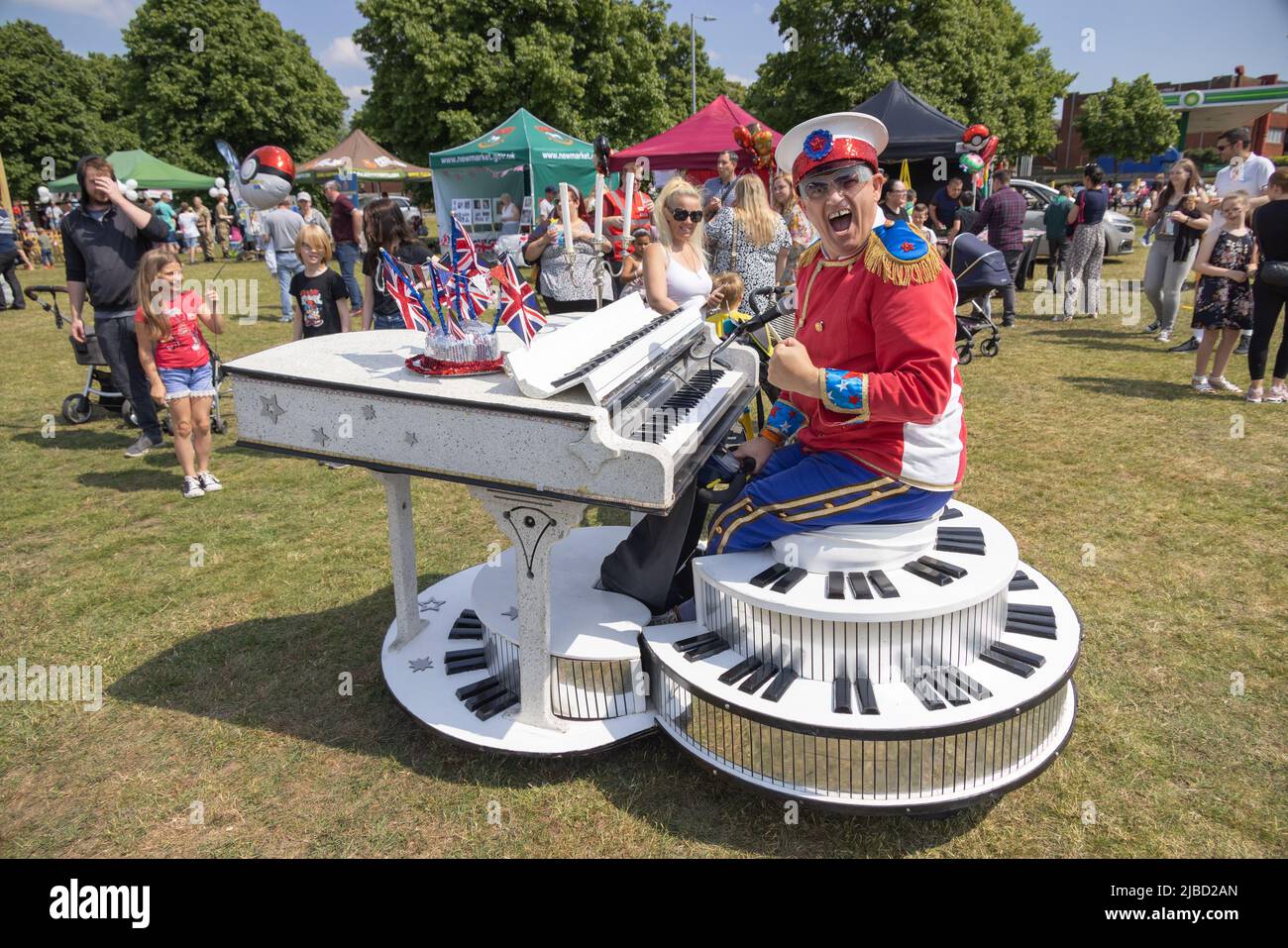 Festeggiamenti del giubileo della regina Elisabetta platino; un Elton John assomigliano - uomo su un piano motorizzato. Eccentrico popolo britannico, Suffolk UK Foto Stock