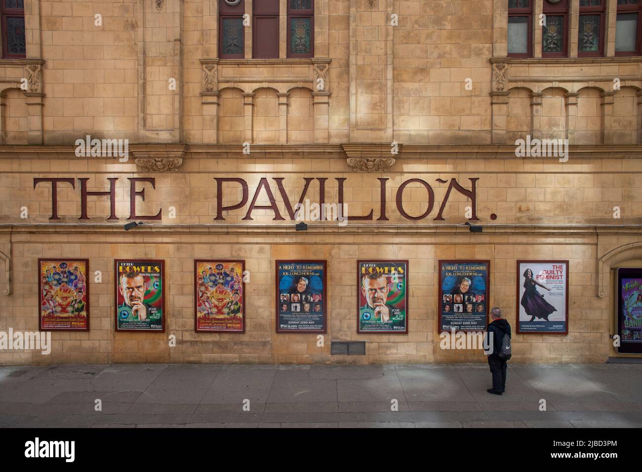 Un uomo che guarda i poster sulla parete esterna del Padiglione di varietà in stile rinascimentale francese su Renfrew Street, Glasgow Foto Stock