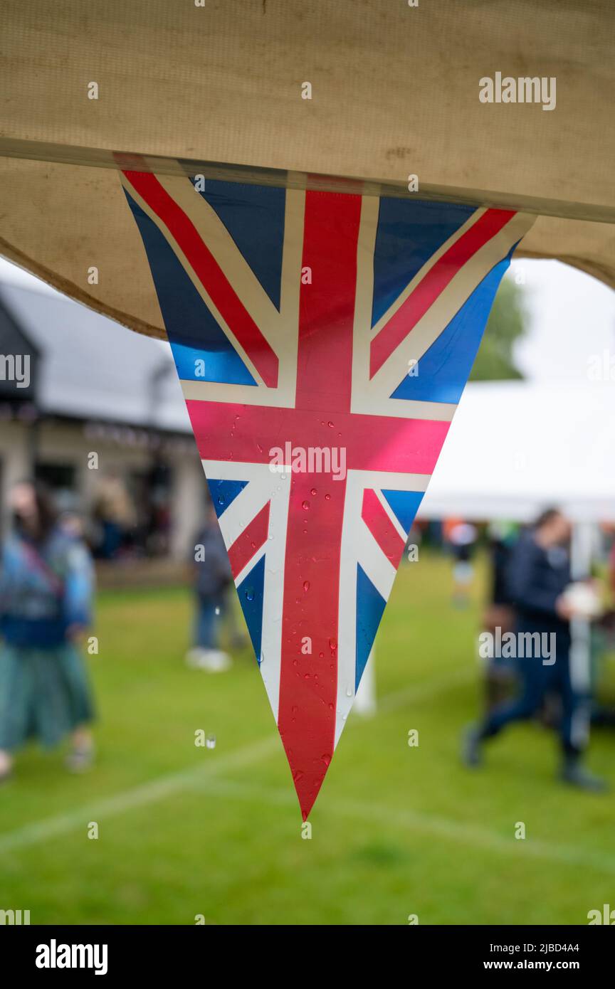 Willingham Cambridgeshire, Regno Unito. 5th giugno 2022. La pioggia gocciola dal bunging mentre la gente celebra il fine settimana del Giubileo del platino della regina nella pioggia ad un picnic sul terreno di ricreazione. Molta gente era determinata a celebrare l'occasione nonostante la pioggia gocciolante, portando i propri picnic e godendo di una band blues, bancarelle di cibo, bar e giochi. Credit: Julian Eales/Alamy Live News Foto Stock Willingham Cambridgeshire, Regno Unito. 5th giugno 2022. La pioggia gocciola dal bunging mentre la gente celebra il fine settimana del Giubileo del platino della regina nella pioggia ad un picnic sul terreno di ricreazione. Molta gente era determinata a celebrare l'occasione nonostante la pioggia gocciolante, portando i propri picnic e godendo di una band blues, bancarelle di cibo, bar e giochi. Credit: Julian Eales/Alamy Live News Foto Stock