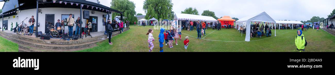 Willingham Cambridgeshire, Regno Unito. 5th giugno 2022. La gente festeggia il fine settimana del Giubileo del platino della Regina sotto la pioggia in un picnic sul terreno ricreativo. Molta gente era determinata a celebrare l'occasione nonostante la pioggia gocciolante, portando i propri picnic e godendo di una band blues, bancarelle di cibo, bar e giochi. Credit: Julian Eales/Alamy Live News Foto Stock Willingham Cambridgeshire, Regno Unito. 5th giugno 2022. La gente festeggia il fine settimana del Giubileo del platino della Regina sotto la pioggia in un picnic sul terreno ricreativo. Molta gente era determinata a celebrare l'occasione nonostante la pioggia gocciolante, portando i propri picnic e godendo di una band blues, bancarelle di cibo, bar e giochi. Credit: Julian Eales/Alamy Live News Foto Stock