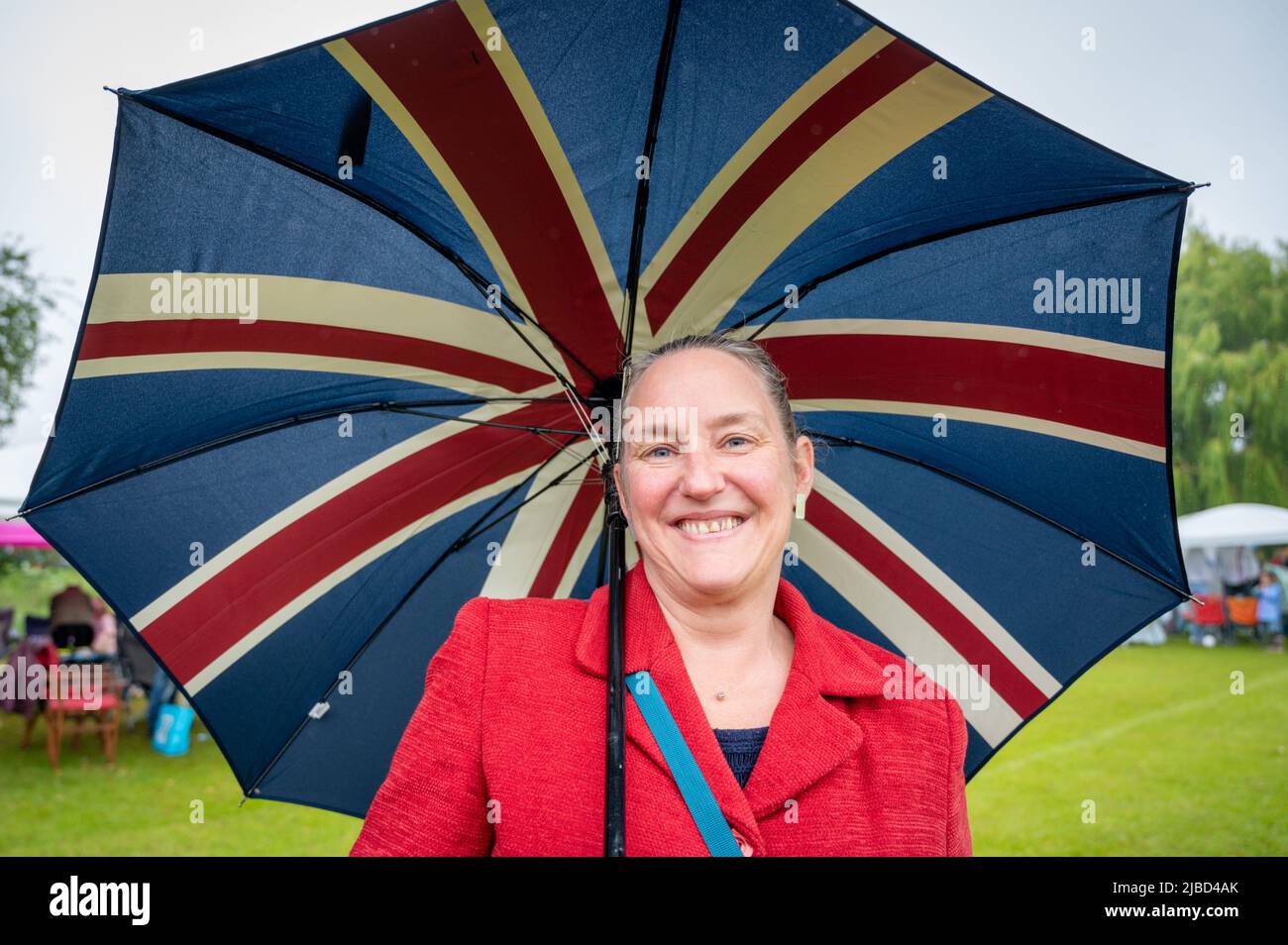 Willingham Cambridgeshire, Regno Unito. 5th giugno 2022. La gente festeggia il fine settimana del Giubileo del platino della Regina sotto la pioggia in un picnic sul terreno ricreativo. Molta gente era determinata a celebrare l'occasione nonostante la pioggia gocciolante, portando i propri picnic e godendo di una band blues, bancarelle di cibo, bar e giochi. Credit: Julian Eales/Alamy Live News Foto Stock Willingham Cambridgeshire, Regno Unito. 5th giugno 2022. La gente festeggia il fine settimana del Giubileo del platino della Regina sotto la pioggia in un picnic sul terreno ricreativo. Molta gente era determinata a celebrare l'occasione nonostante la pioggia gocciolante, portando i propri picnic e godendo di una band blues, bancarelle di cibo, bar e giochi. Credit: Julian Eales/Alamy Live News Foto Stock