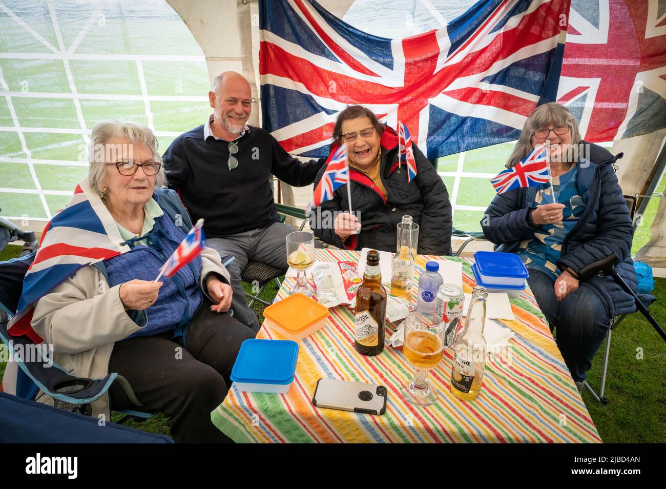 Willingham Cambridgeshire, Regno Unito. 5th giugno 2022. La gente festeggia il fine settimana del Giubileo del platino della Regina sotto la pioggia in un picnic sul terreno ricreativo. Molta gente era determinata a celebrare l'occasione nonostante la pioggia gocciolante, portando i propri picnic e godendo di una band blues, bancarelle di cibo, bar e giochi. Credit: Julian Eales/Alamy Live News Foto Stock Willingham Cambridgeshire, Regno Unito. 5th giugno 2022. La gente festeggia il fine settimana del Giubileo del platino della Regina sotto la pioggia in un picnic sul terreno ricreativo. Molta gente era determinata a celebrare l'occasione nonostante la pioggia gocciolante, portando i propri picnic e godendo di una band blues, bancarelle di cibo, bar e giochi. Credit: Julian Eales/Alamy Live News Foto Stock