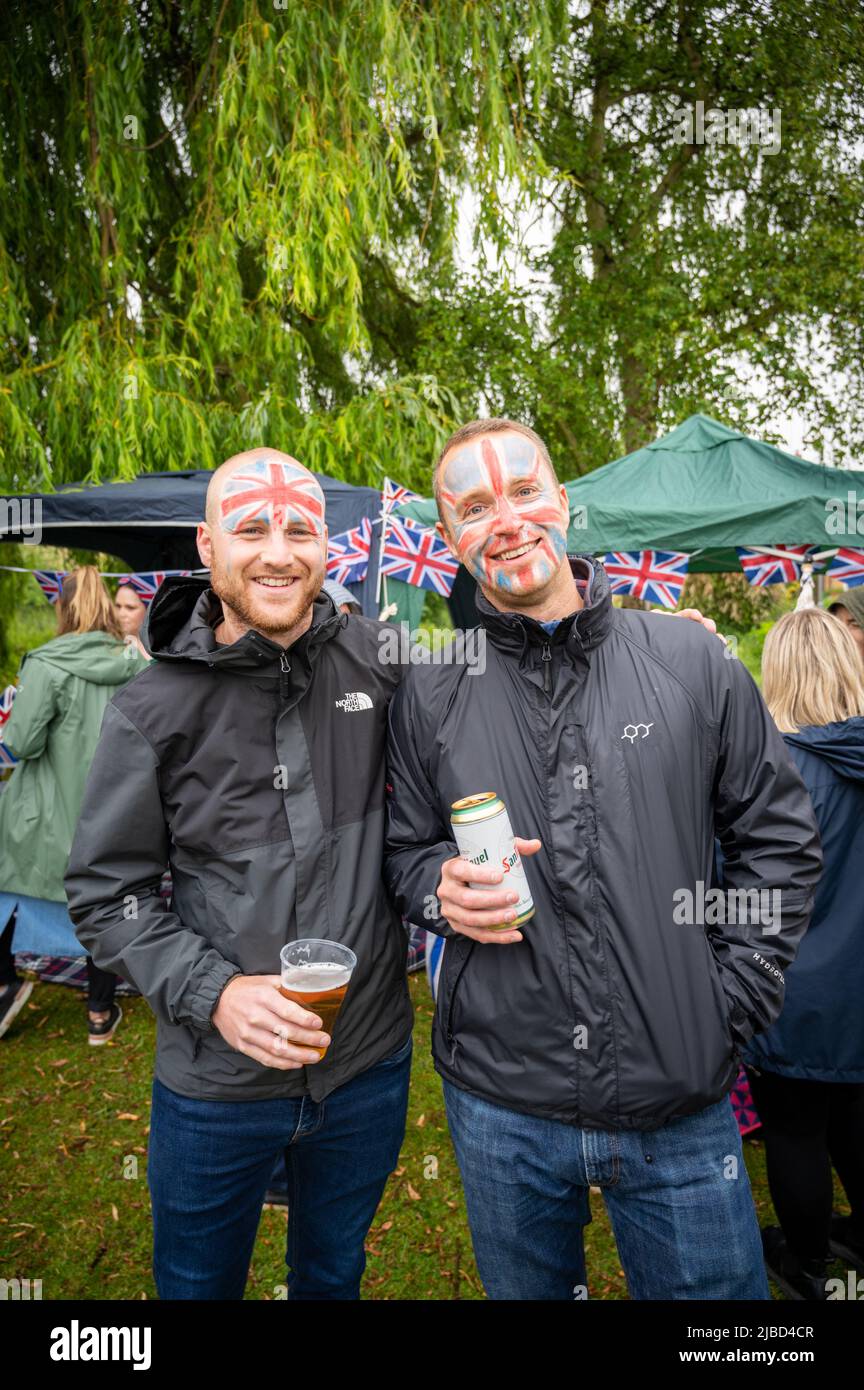 Willingham Cambridgeshire, Regno Unito. 5th giugno 2022. La gente festeggia il fine settimana del Giubileo del platino della Regina sotto la pioggia in un picnic sul terreno ricreativo. Molta gente era determinata a celebrare l'occasione nonostante la pioggia gocciolante, portando i propri picnic e godendo di una band blues, bancarelle di cibo, bar e giochi. Credit: Julian Eales/Alamy Live News Foto Stock Willingham Cambridgeshire, Regno Unito. 5th giugno 2022. La gente festeggia il fine settimana del Giubileo del platino della Regina sotto la pioggia in un picnic sul terreno ricreativo. Molta gente era determinata a celebrare l'occasione nonostante la pioggia gocciolante, portando i propri picnic e godendo di una band blues, bancarelle di cibo, bar e giochi. Credit: Julian Eales/Alamy Live News Foto Stock