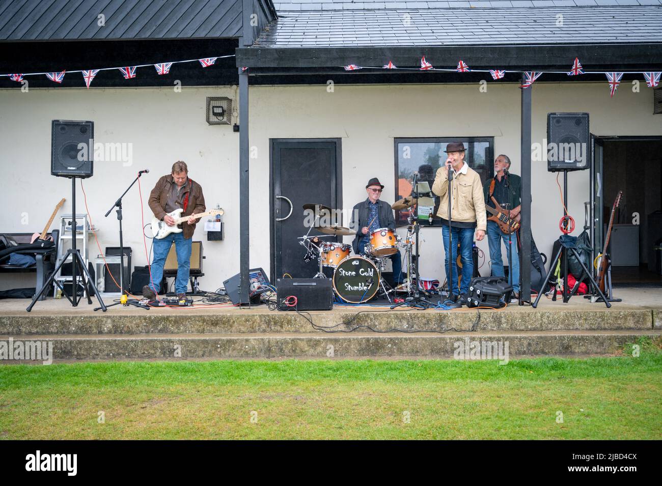 Willingham Cambridgeshire, Regno Unito. 5th giugno 2022. La gente festeggia il fine settimana del Giubileo del platino della Regina sotto la pioggia in un picnic sul terreno ricreativo. Molta gente era determinata a celebrare l'occasione nonostante la pioggia gocciolante, portando i propri picnic e godendo di una band blues, bancarelle di cibo, bar e giochi. Credit: Julian Eales/Alamy Live News Foto Stock Willingham Cambridgeshire, Regno Unito. 5th giugno 2022. La gente festeggia il fine settimana del Giubileo del platino della Regina sotto la pioggia in un picnic sul terreno ricreativo. Molta gente era determinata a celebrare l'occasione nonostante la pioggia gocciolante, portando i propri picnic e godendo di una band blues, bancarelle di cibo, bar e giochi. Credit: Julian Eales/Alamy Live News Foto Stock