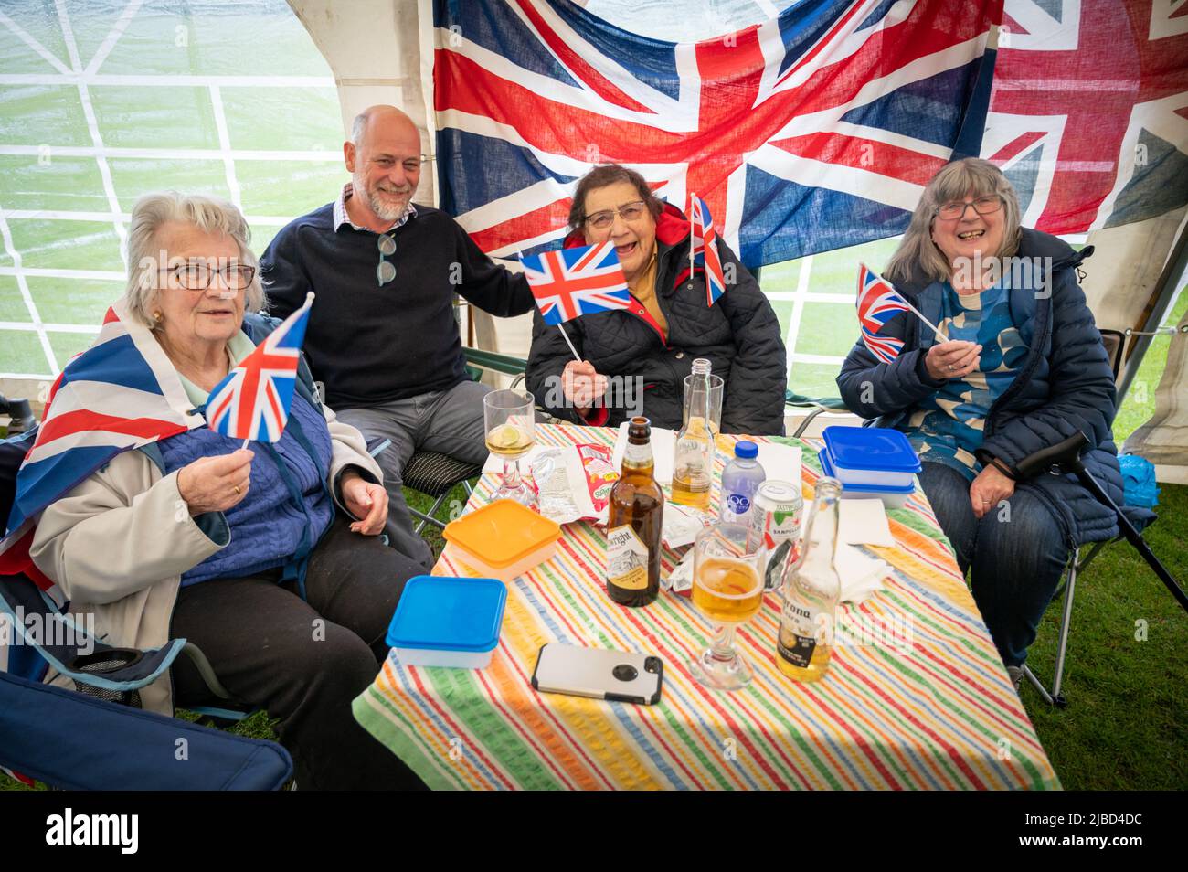 Willingham Cambridgeshire, Regno Unito. 5th giugno 2022. La gente festeggia il fine settimana del Giubileo del platino della Regina sotto la pioggia in un picnic sul terreno ricreativo. Molta gente era determinata a celebrare l'occasione nonostante la pioggia gocciolante, portando i propri picnic e godendo di una band blues, bancarelle di cibo, bar e giochi. Credit: Julian Eales/Alamy Live News Foto Stock Willingham Cambridgeshire, Regno Unito. 5th giugno 2022. La gente festeggia il fine settimana del Giubileo del platino della Regina sotto la pioggia in un picnic sul terreno ricreativo. Molta gente era determinata a celebrare l'occasione nonostante la pioggia gocciolante, portando i propri picnic e godendo di una band blues, bancarelle di cibo, bar e giochi. Credit: Julian Eales/Alamy Live News Foto Stock