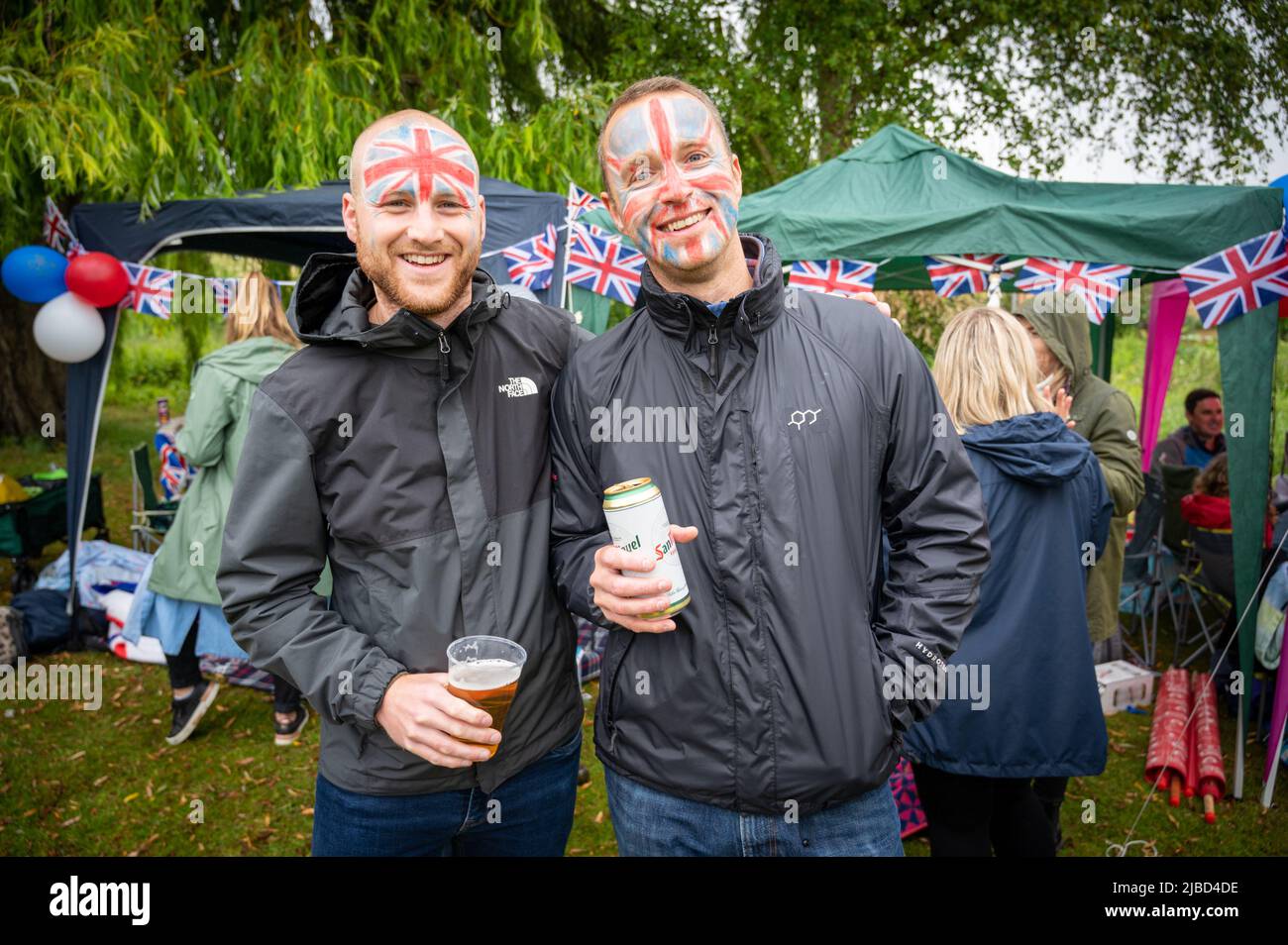 Willingham Cambridgeshire, Regno Unito. 5th giugno 2022. La gente festeggia il fine settimana del Giubileo del platino della Regina sotto la pioggia in un picnic sul terreno ricreativo. Molta gente era determinata a celebrare l'occasione nonostante la pioggia gocciolante, portando i propri picnic e godendo di una band blues, bancarelle di cibo, bar e giochi. Credit: Julian Eales/Alamy Live News Foto Stock Willingham Cambridgeshire, Regno Unito. 5th giugno 2022. La gente festeggia il fine settimana del Giubileo del platino della Regina sotto la pioggia in un picnic sul terreno ricreativo. Molta gente era determinata a celebrare l'occasione nonostante la pioggia gocciolante, portando i propri picnic e godendo di una band blues, bancarelle di cibo, bar e giochi. Credit: Julian Eales/Alamy Live News Foto Stock
