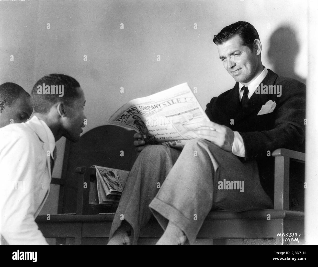 CLARK GABLE nel 1936 leggendo un giornale mentre le sue scarpe brillavano  da un ragazzo nero