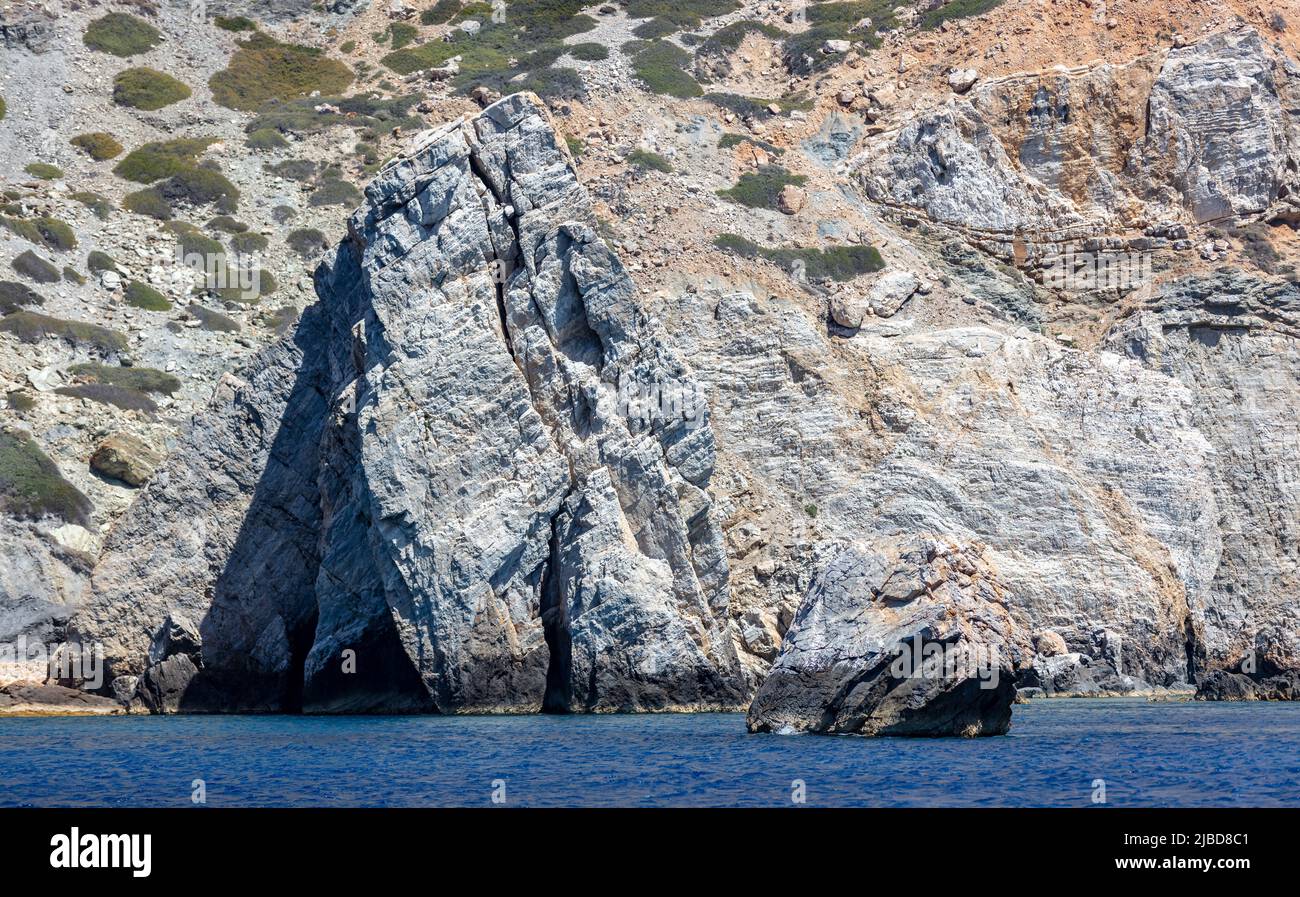 Mar Egeo. Formazioni rocciose, scogliere e grotte, acqua dell'oceano increspata. CICLADI Grecia. Seascape vicino all'isola di iOS, giorno di sole Foto Stock