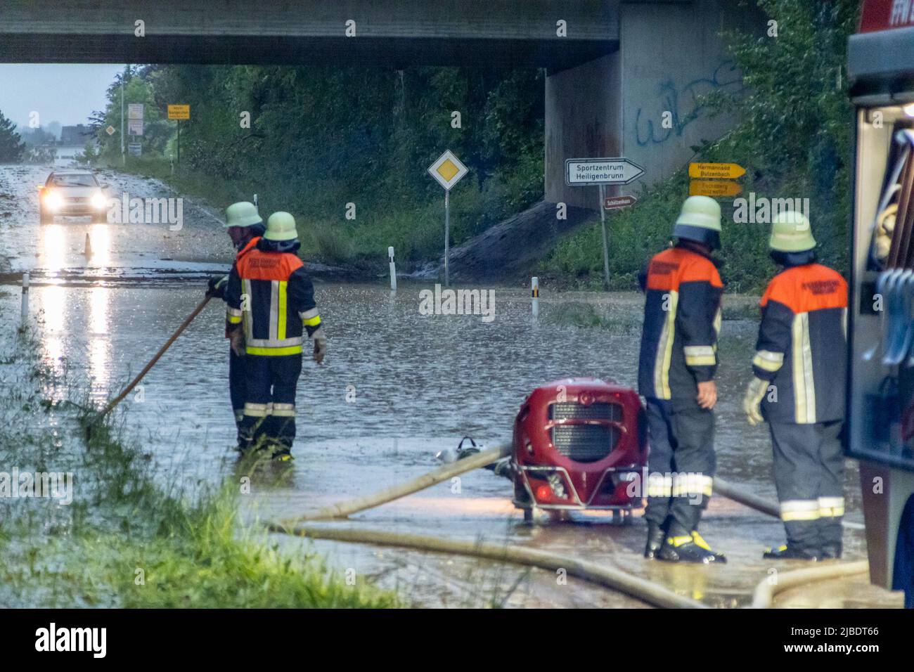 Neumarkt Sankt Veit, Germania. 05th giugno 2022. I vigili del fuoco pompano l'acqua da una strada allagata. In Baviera a Whitsunday, oltre alle forti piogge, si sono avutate anche forti temporali e forti raffiche di vento. La polizia ha detto che cadde una tempesta di grandine. Credit: André März/dpa/Alamy Live News Foto Stock