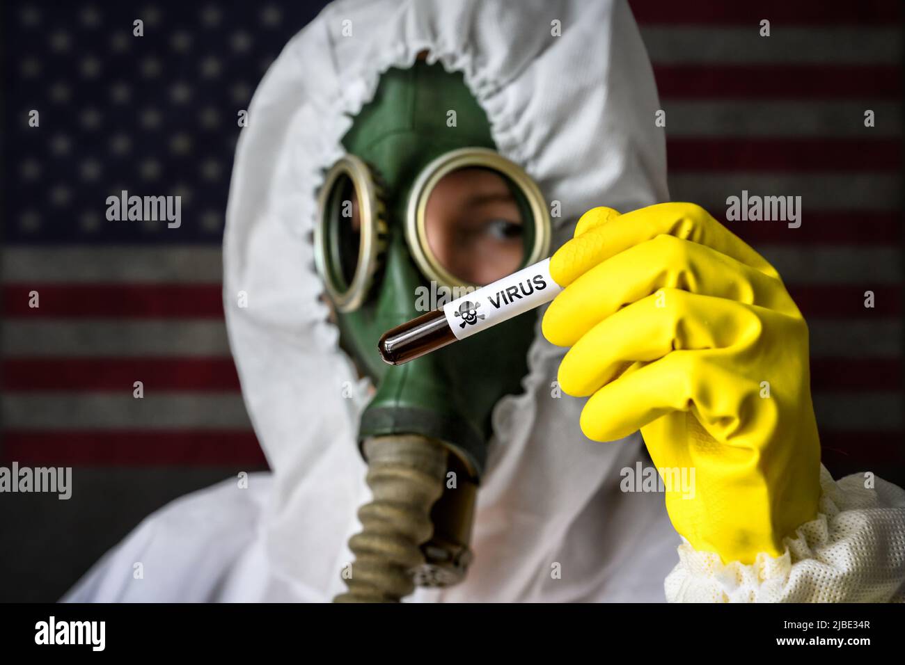 Secret Lab, scienziato in tuta protettiva e maschera per gas contiene provetta con virus pericoloso su sfondo bandiera USA. Concetto di sostanza chimica tossica e biolo Foto Stock