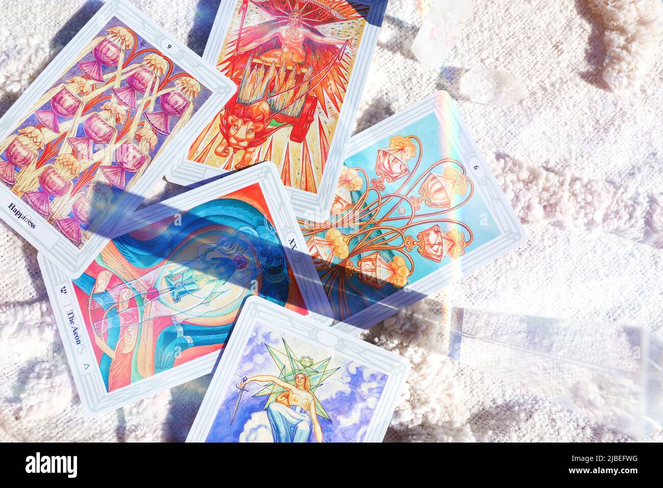Thoth astrologia Tarot Card Deck su sfondo marmo bianco con prisma chiaro arcobaleno e sognanti ombre floreali Foto Stock