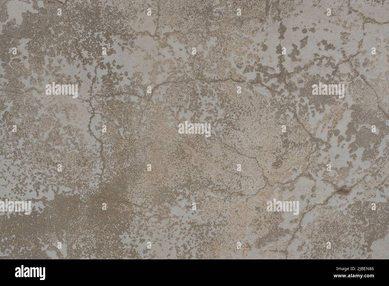 Vecchia trama della parete con due strati di vernice di peeling. Superficie di una vecchia parete logorata incrinata con strati di vernice da peeling beige e bianca. Foto Stock
