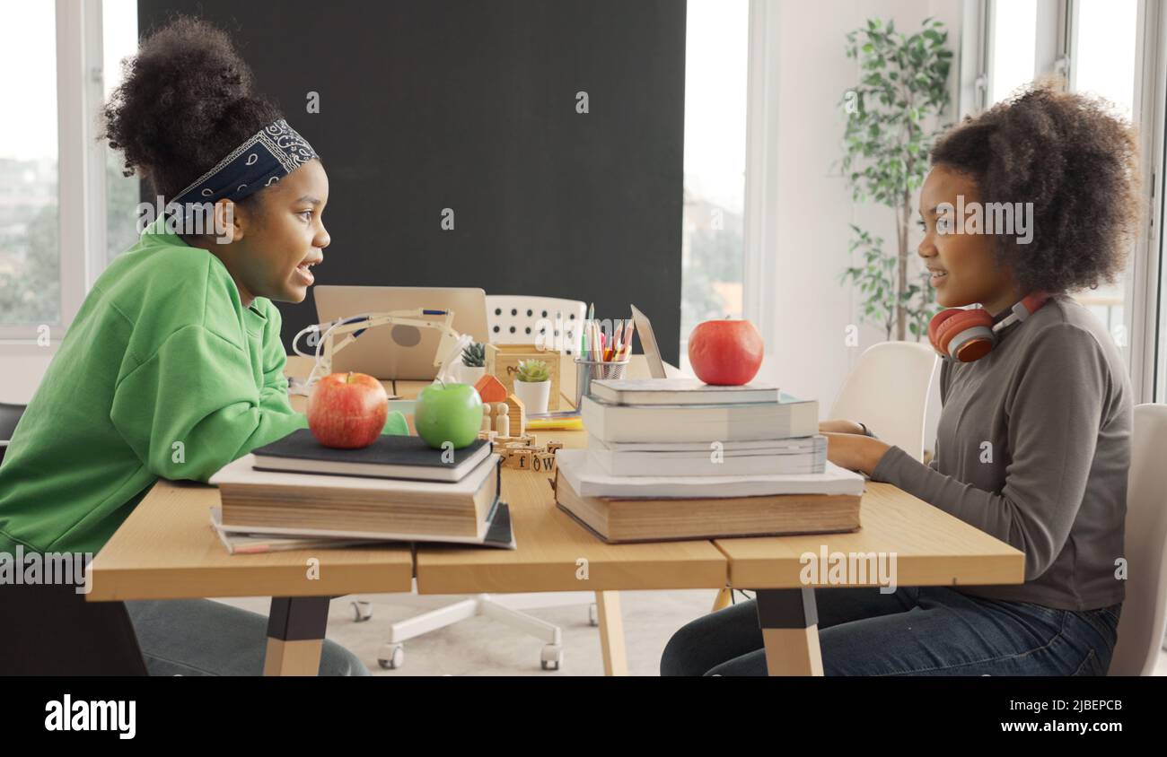 Gli studenti afroamericani parlano felicemente mentre condividono i loro pensieri nella sala di studio. Foto Stock