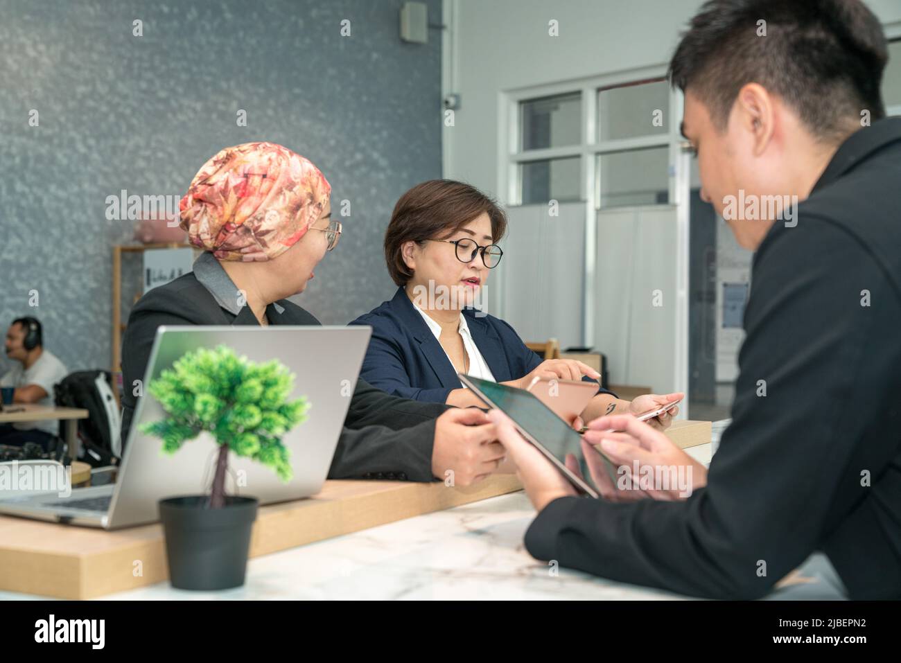 Gruppo di uomini d'affari asiatici che lavorano insieme in un moderno spazio di co-lavoro. Foto Stock