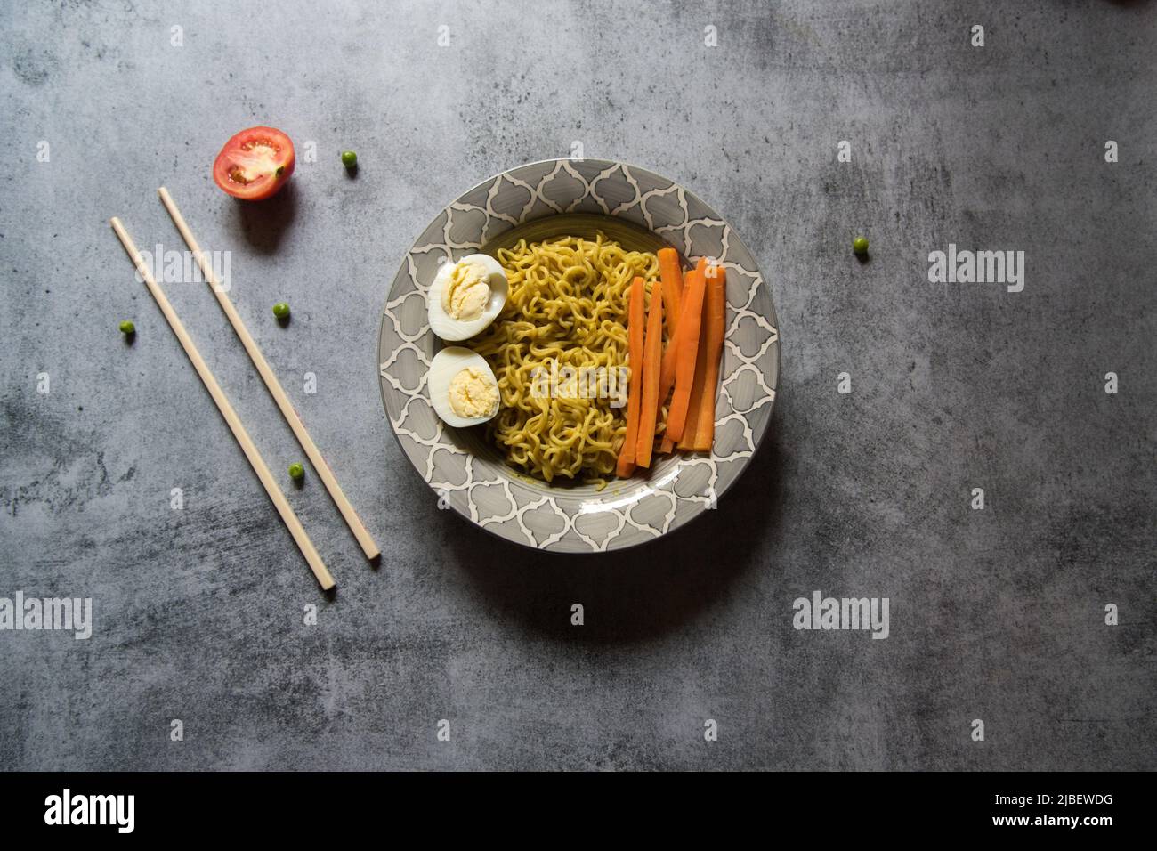 Piatti cotti ramen noodle serviti in una ciotola su sfondo. Primo piano, messa a fuoco selettiva. Foto Stock