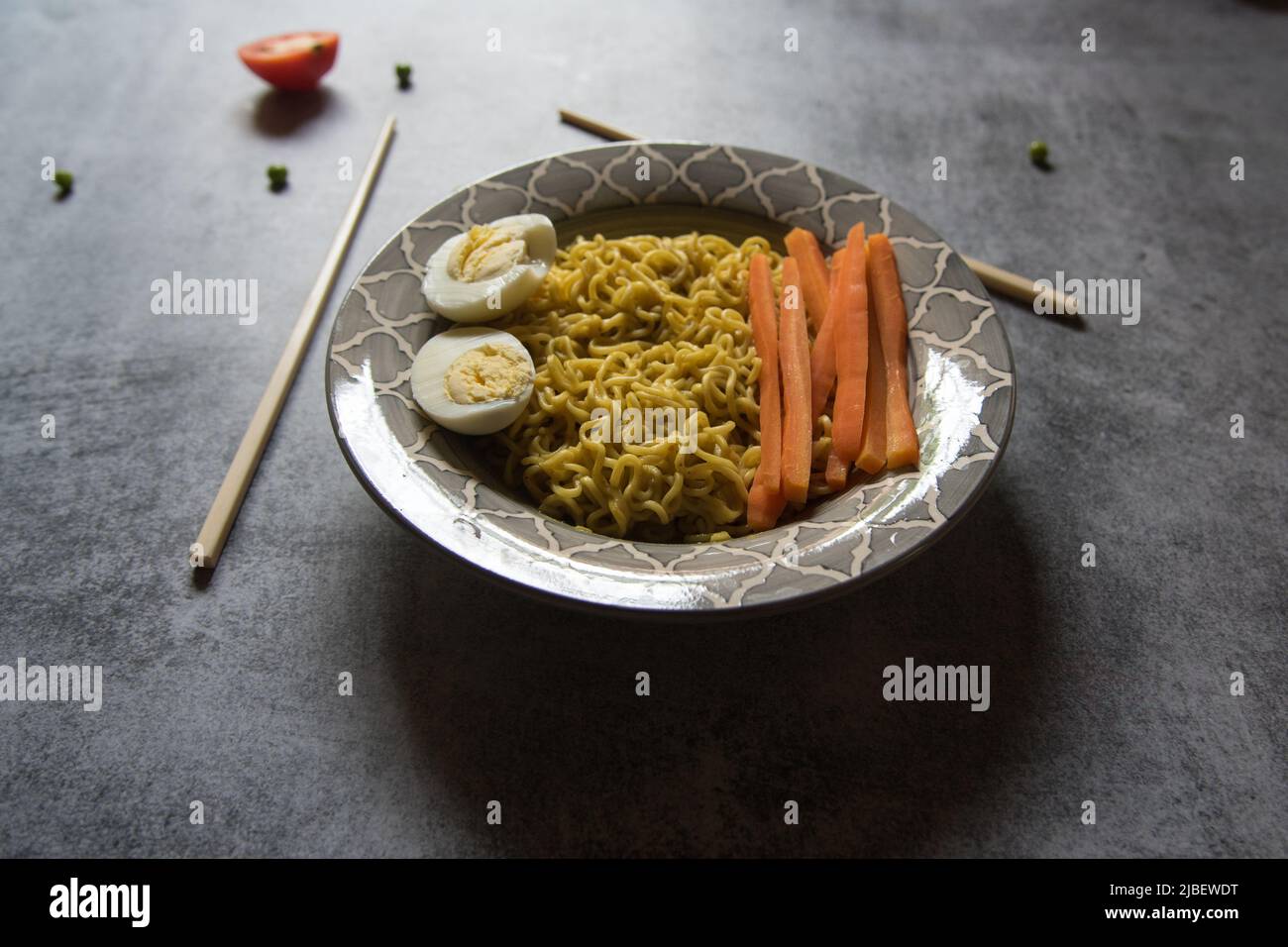Piatti cotti ramen noodle serviti in una ciotola su sfondo. Primo piano, messa a fuoco selettiva. Foto Stock