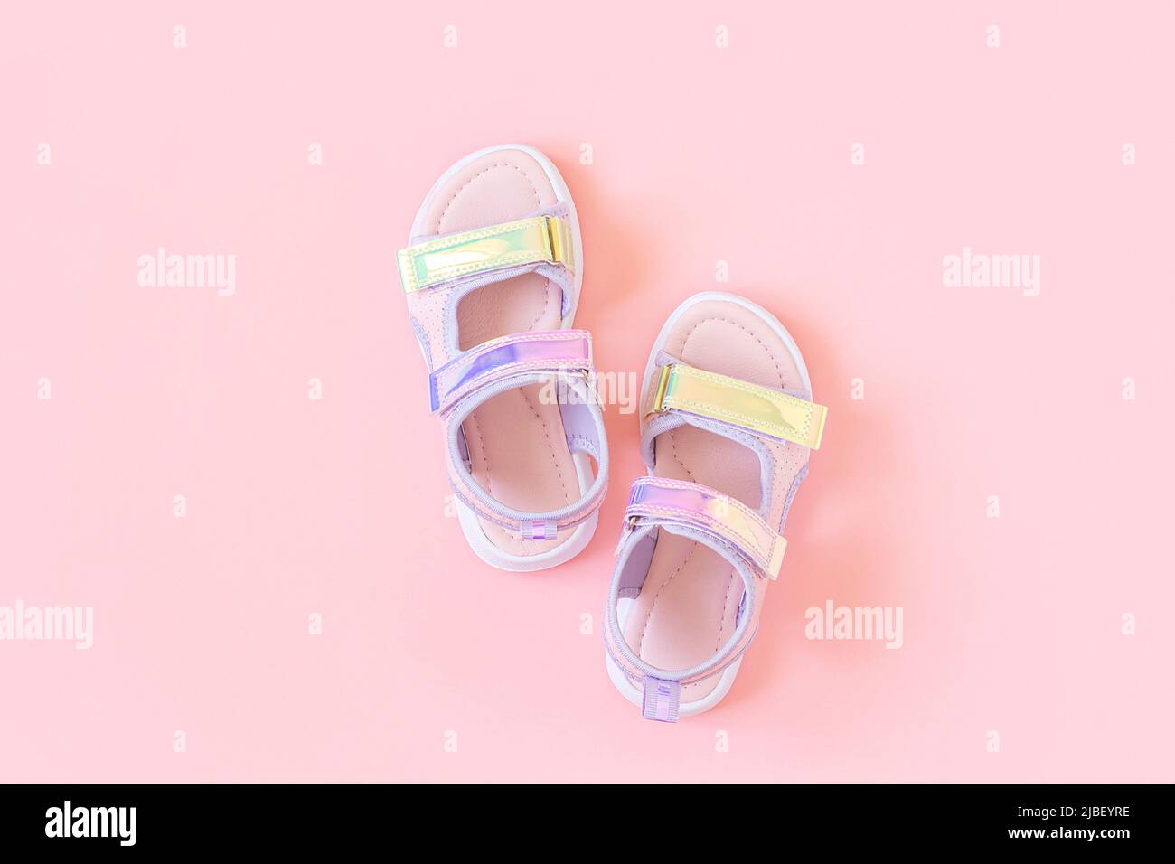 Eleganti sandali olografici per bambini su sfondo rosa. Scarpe estive alla  moda lucenti. Disposizione piatta, vista dall'alto Foto stock - Alamy