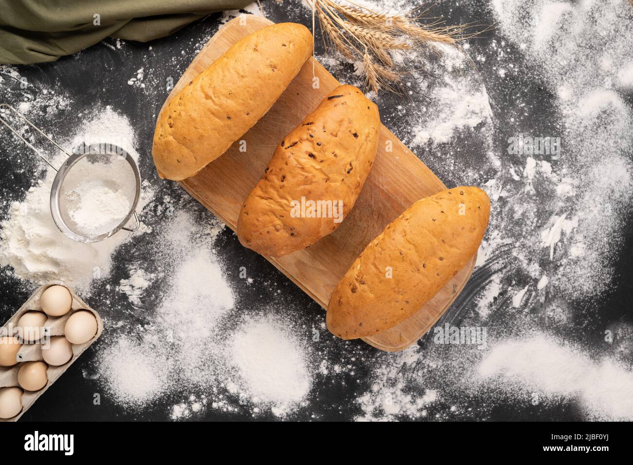 tre pani di pane di grano, mais e segale. Varietà di prodotti da forno su sfondo di legno. Concetto di mini panetteria. Foto Stock
