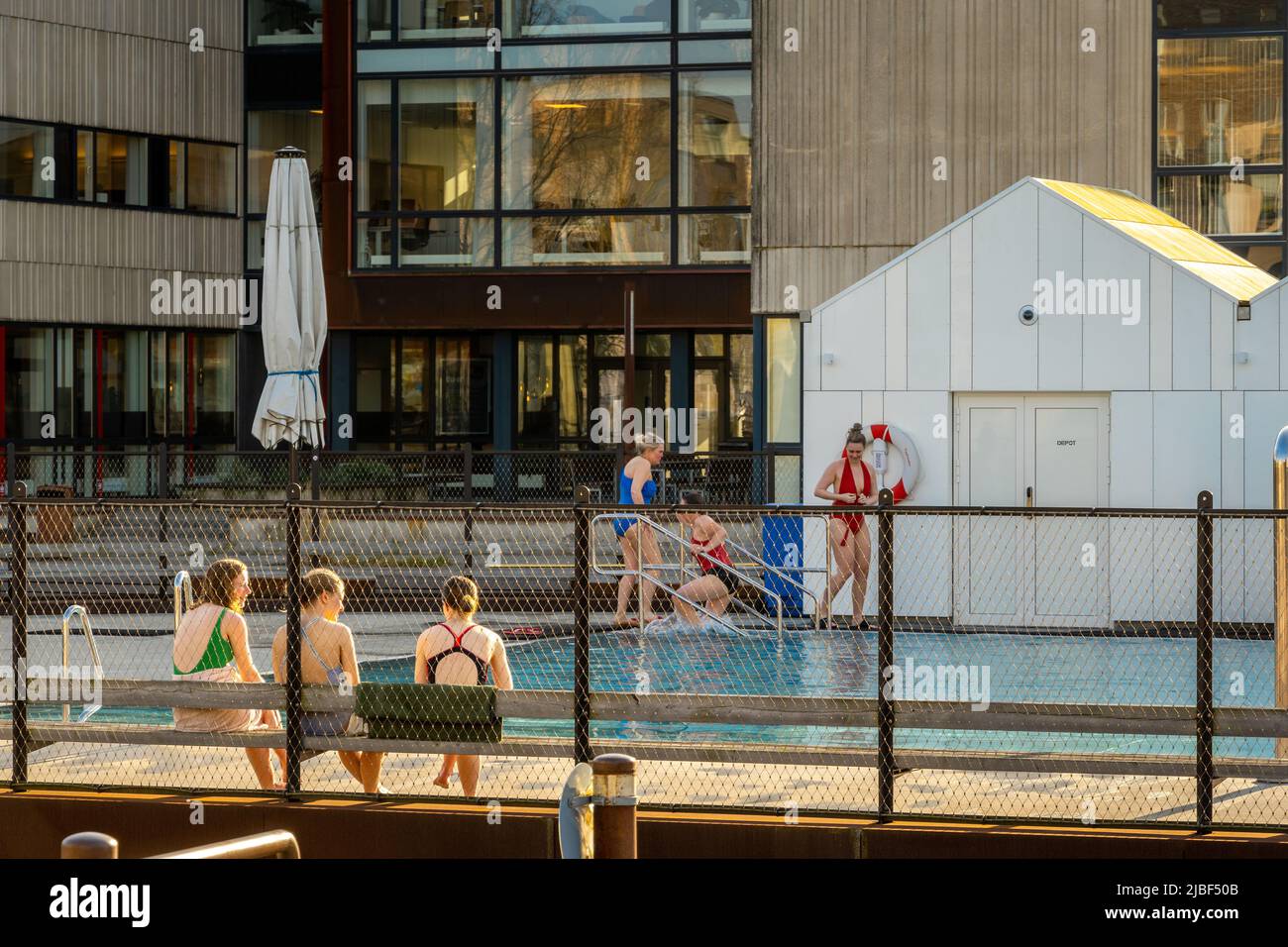 Bagnanti presso la piscina di Odense Havnebad in una soleggiata giornata di primavera. Odense, Funen Island (Fyn), Danimarca Foto Stock