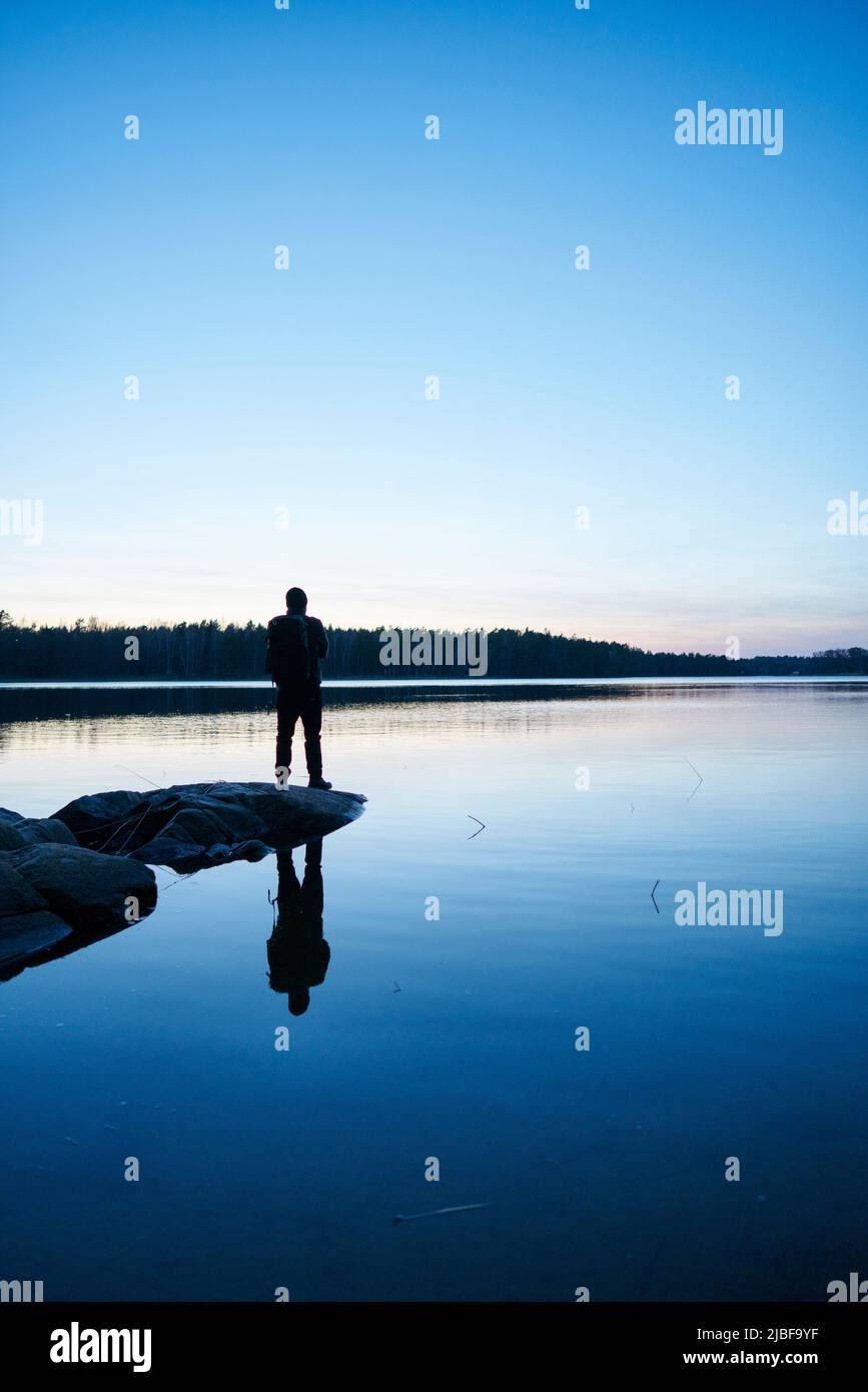 Silhouette di uomo al mare al tramonto a Bjorno, Svezia Foto Stock