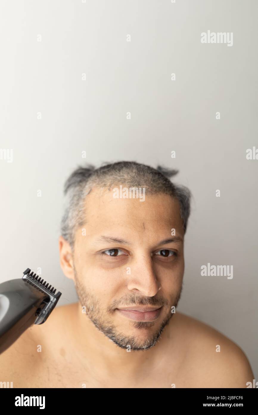 Bell'uomo dai capelli grigi sta tagliando i capelli. Foto Stock