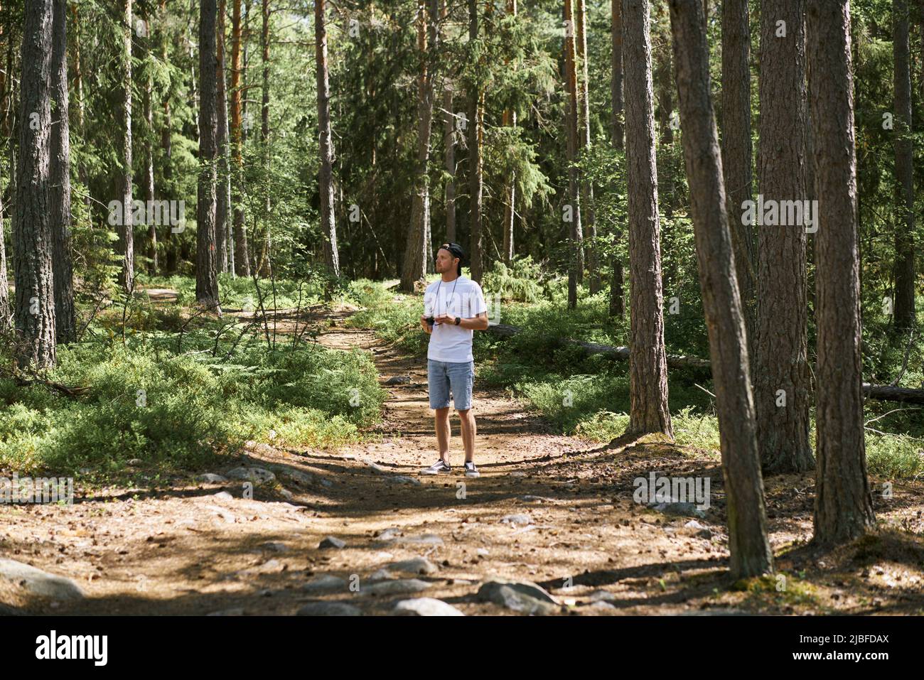 Uomo in piedi nella foresta Foto Stock