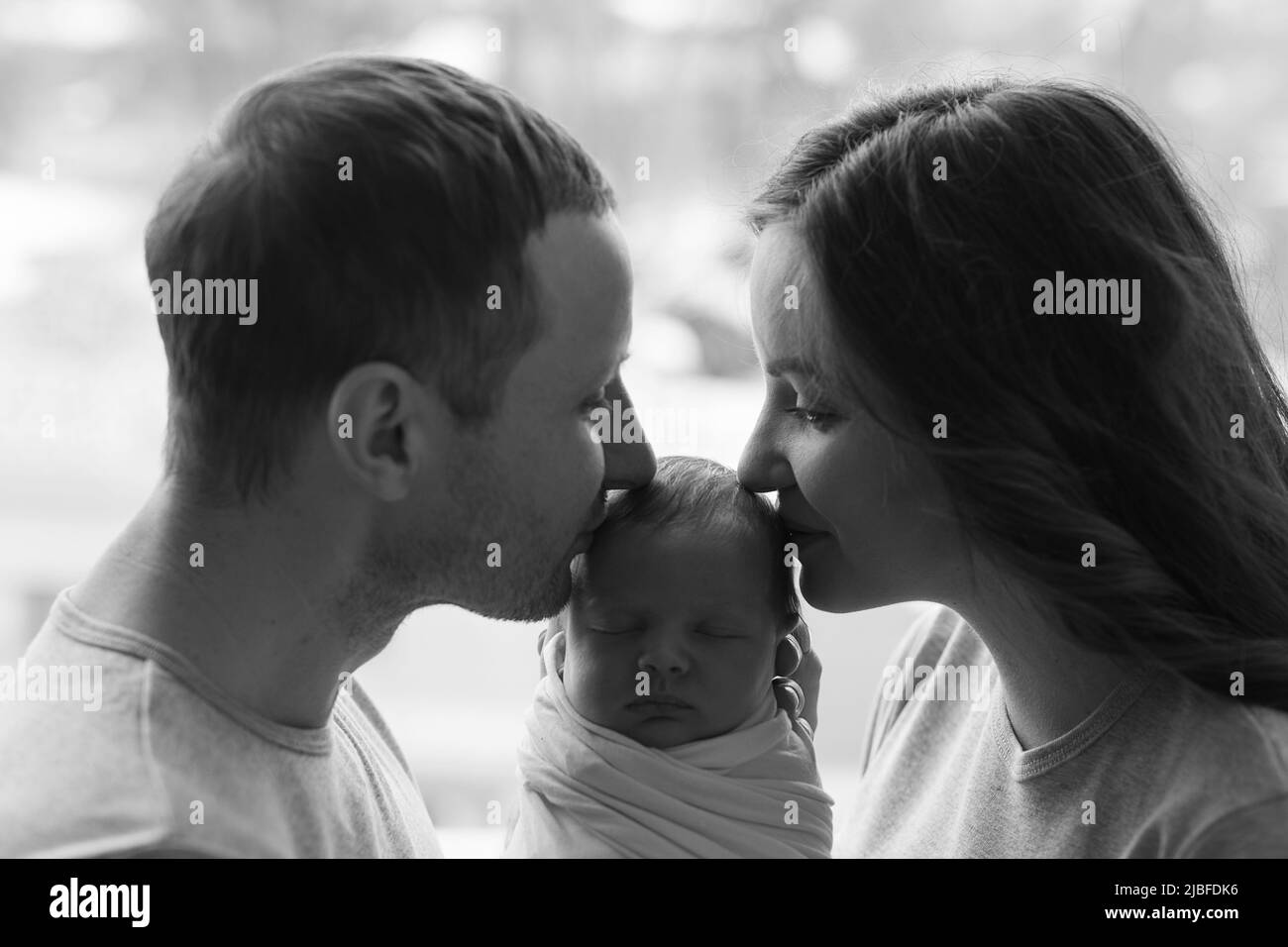 Neonato nelle braccia di madre e padre. Cartolina il giorno della madre e del padre. Giorno di protezione dei bambini. Giornata mondiale della felicità. Bambino sorridente. Buon par Foto Stock