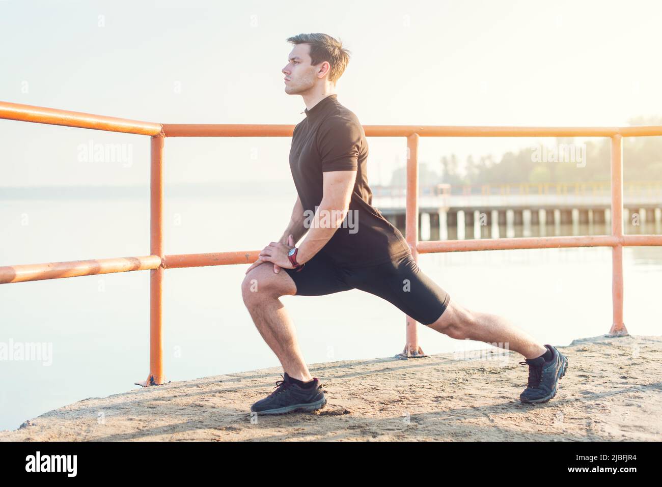 Fitness uomo che allunga i muscoli delle gambe all'aperto Foto Stock