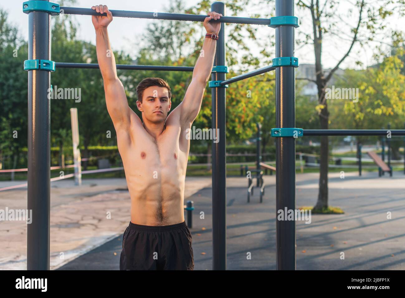 Fynes uomo appeso su barre di parete. Core cross training allenando i muscoli abs. Foto Stock