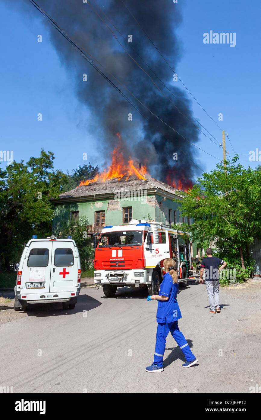 Russia, Rostov-on-Don - 2 giugno 2022: I vigili del fuoco sono arrivati per estinguere un incendio in una casa abbandonata, un'ambulanza, medici e spettatori sono st Foto Stock