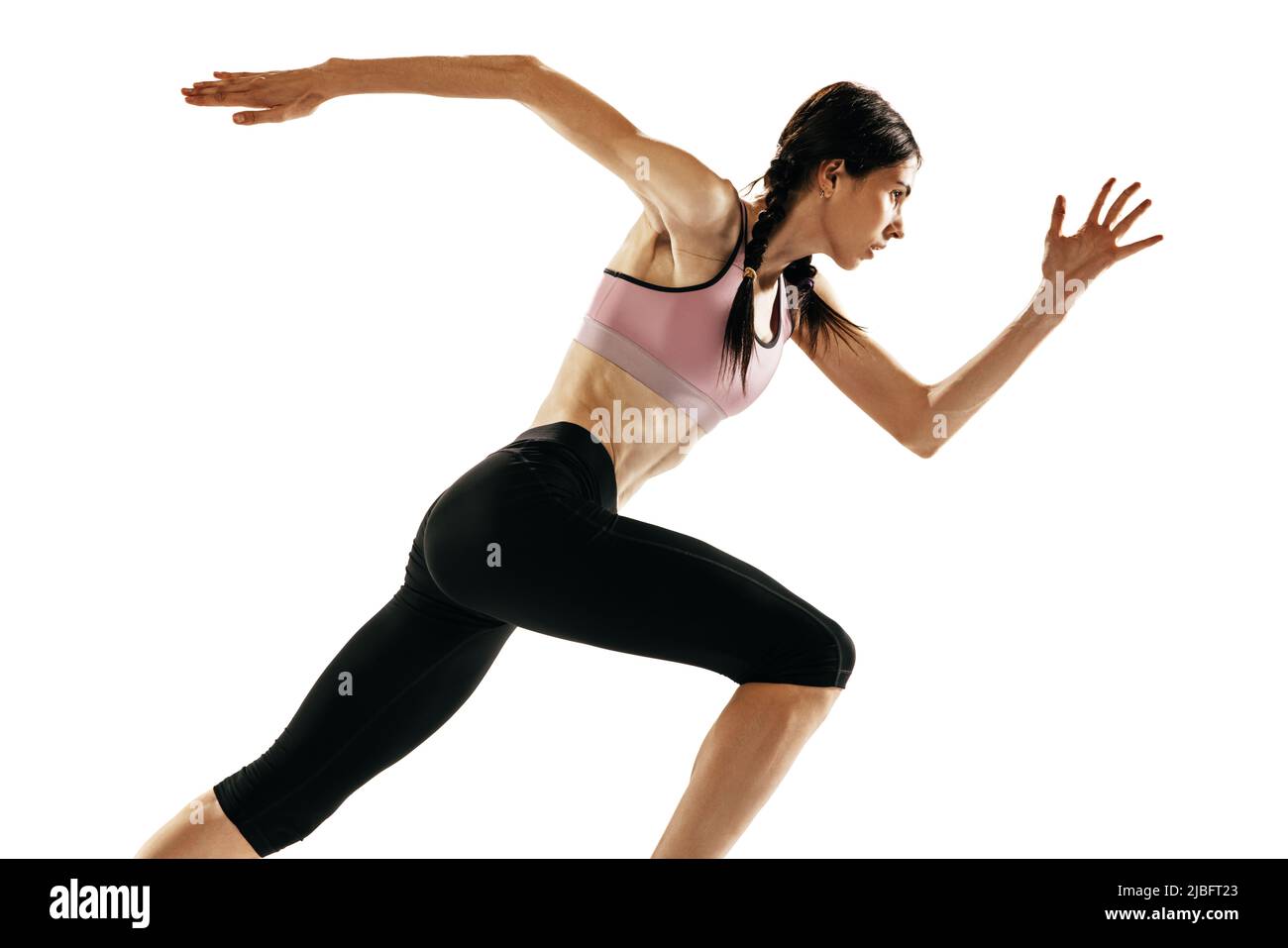 Ritratto di giovane donna muscolare che corre isolato su sfondo bianco. Un corridore femmina o pareggiatore. Sport, atletica su pista e campo, competizione Foto Stock