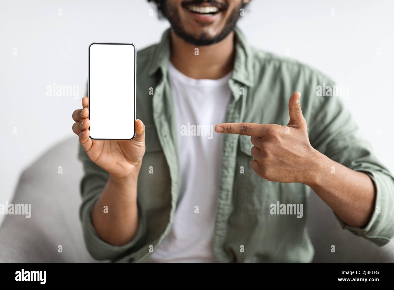 Un uomo che punta allo smartphone con uno schermo vuoto Foto Stock