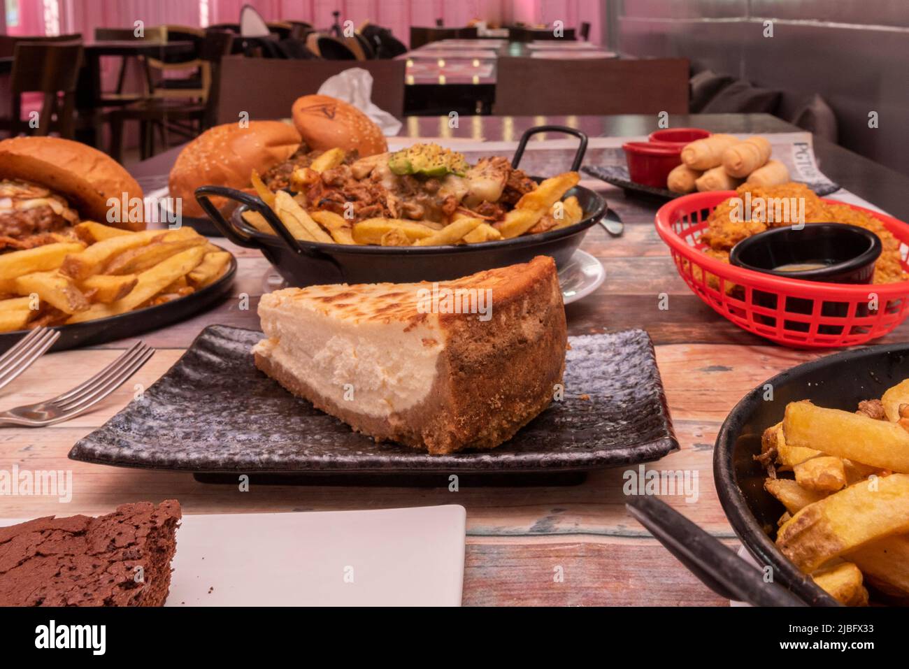 piatti di cibo su un tavolo con cheesecake in primo piano Foto Stock