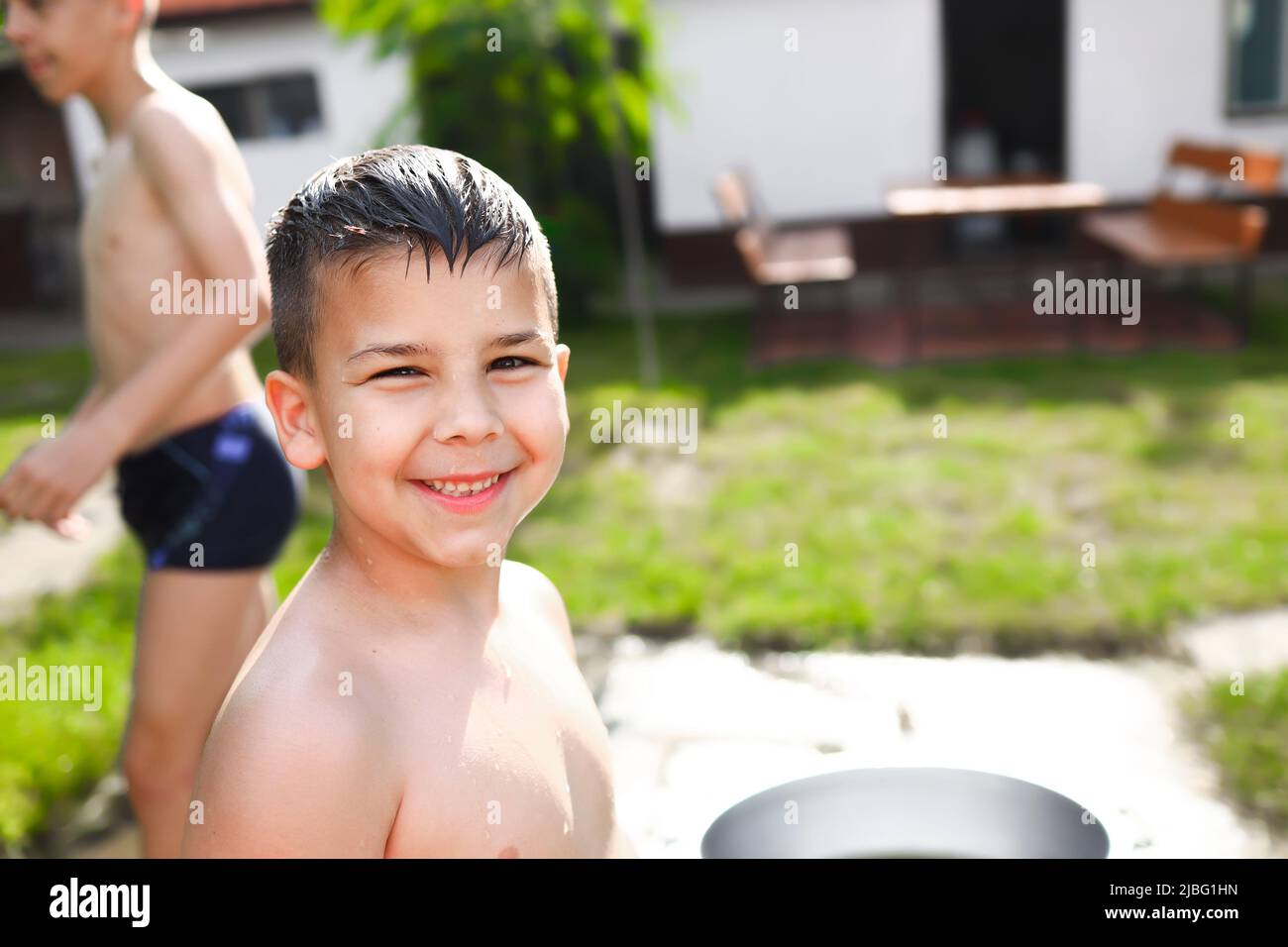 Ritratto di un ragazzo sorridente mentre si diverte a giocare nel cortile Foto Stock