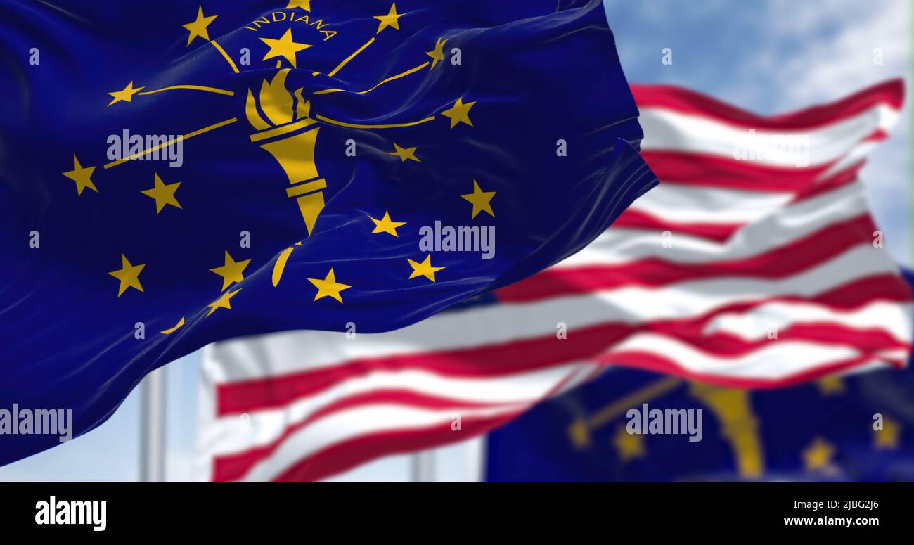 La bandiera dello stato dell'Indiana sventola insieme alla bandiera nazionale degli Stati Uniti d'America. Sullo sfondo c'è un cielo limpido. L'Indiana è un americano Foto Stock