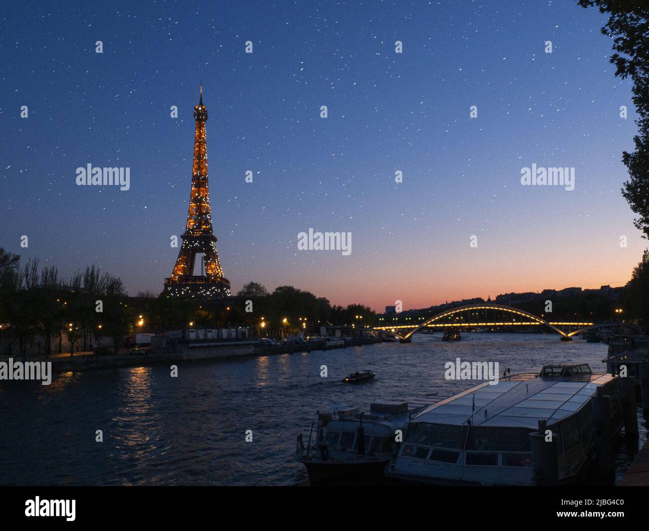 Torre eiffel illuminata al tramonto Foto Stock