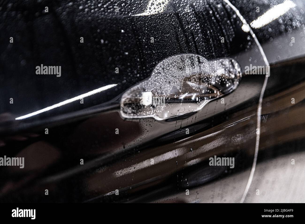 Tecnico di dettaglio dell'auto che applica una lamina ppf trasparente Foto Stock